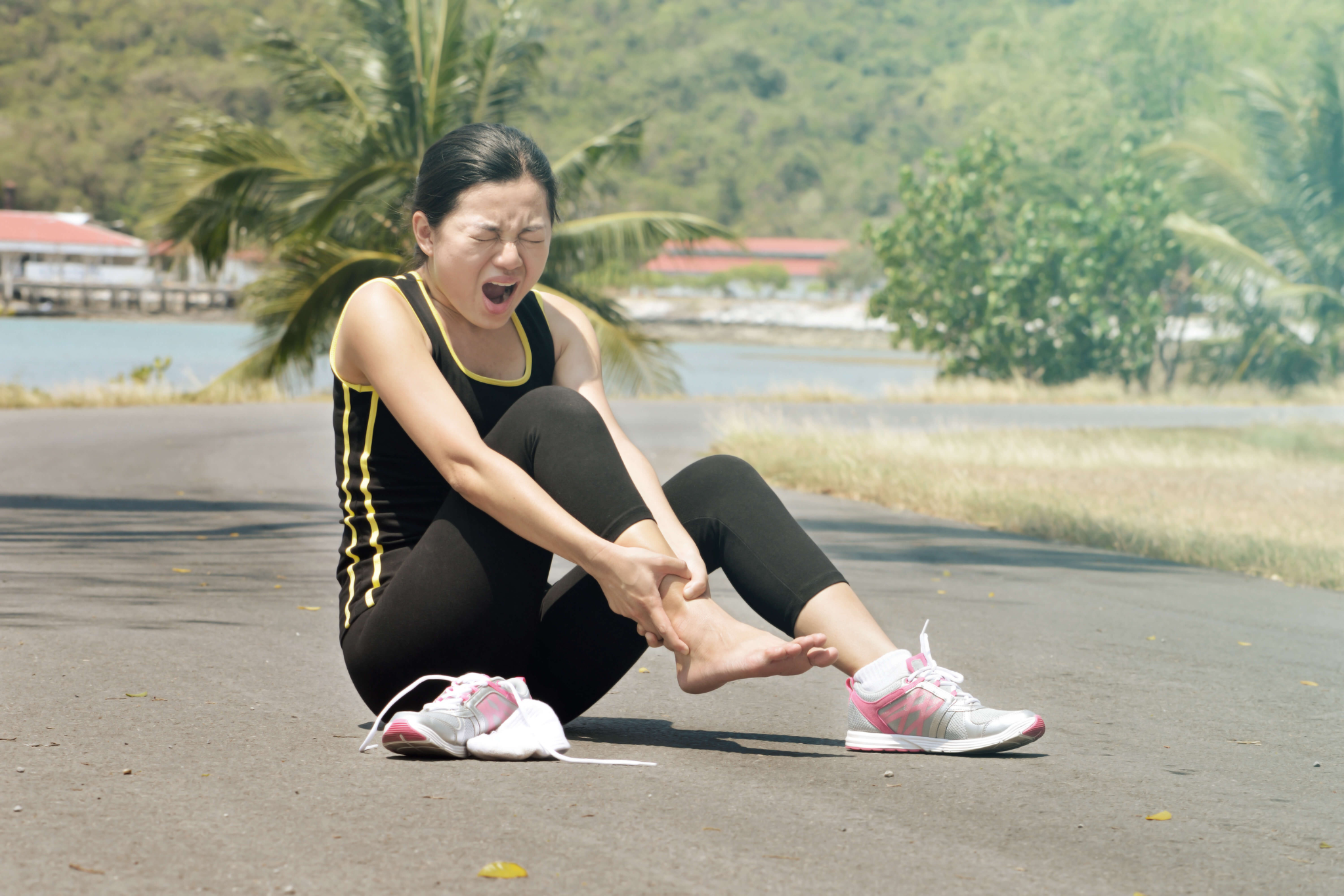 Sports injury. Woman with pain in ankle while jogging