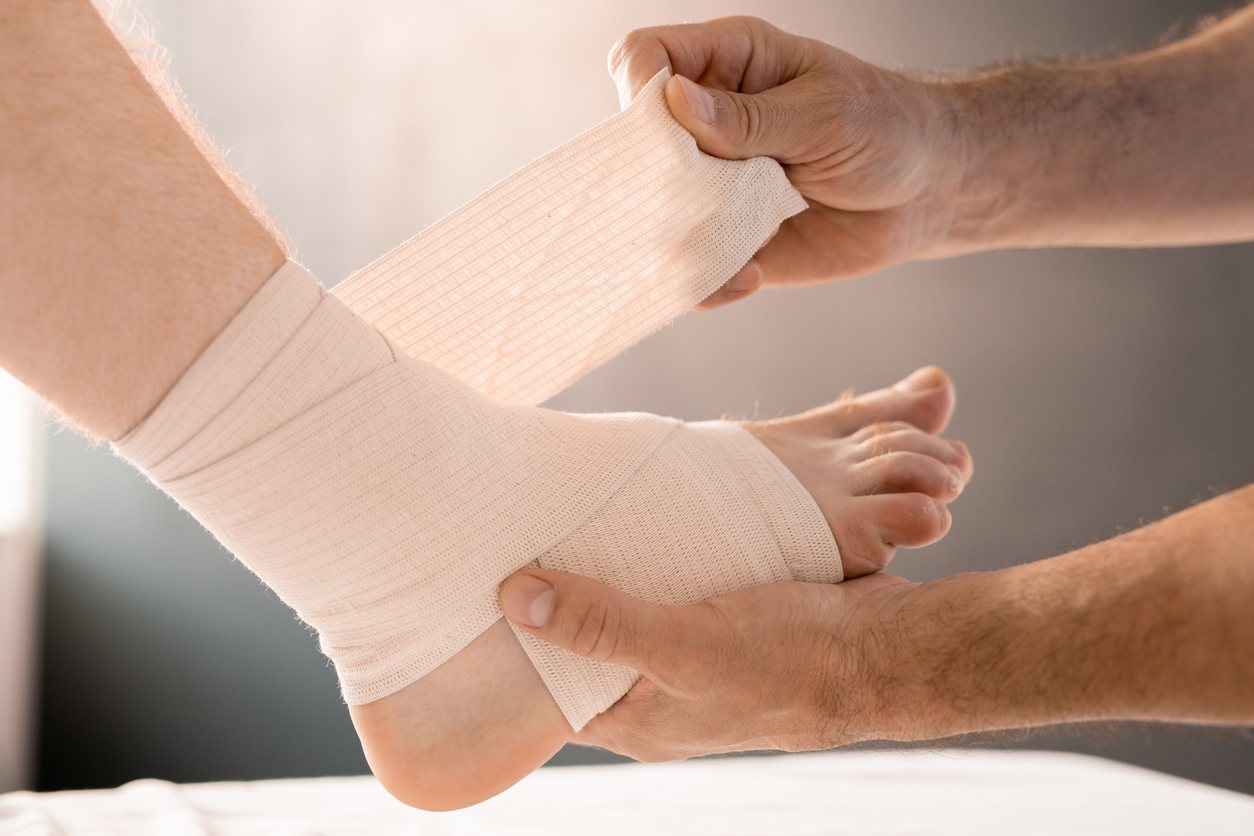 Ankle being wrapped with a compression bandage
